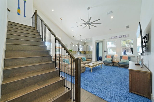 living room featuring a high ceiling, hardwood / wood-style floors, and ceiling fan