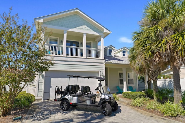 raised beach house with a garage and a balcony