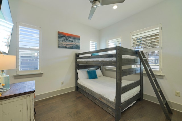 bedroom with ceiling fan, dark hardwood / wood-style flooring, and multiple windows