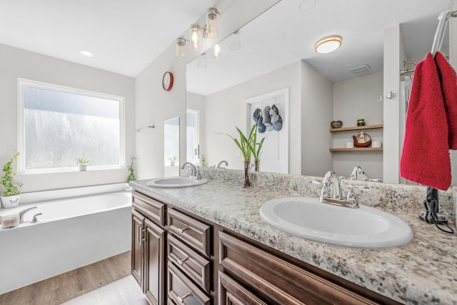 bathroom with vanity, a washtub, and hardwood / wood-style flooring