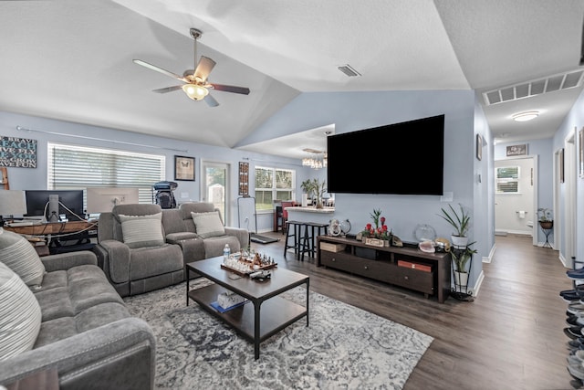 living room featuring ceiling fan with notable chandelier, lofted ceiling, and dark hardwood / wood-style floors