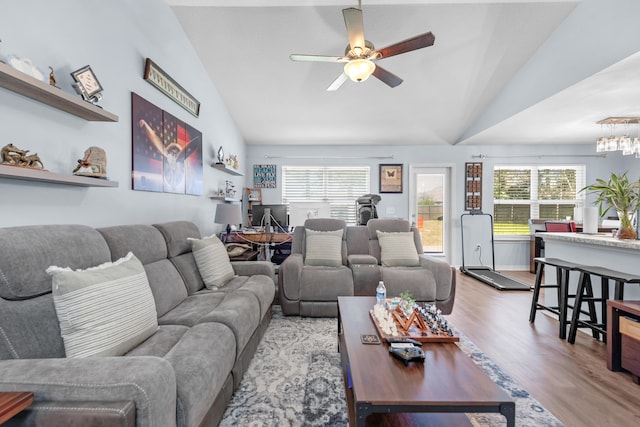 living room featuring lofted ceiling, light hardwood / wood-style floors, and a healthy amount of sunlight