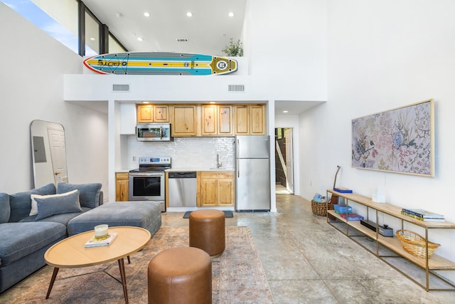 living room featuring a towering ceiling and sink