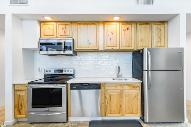 kitchen featuring decorative backsplash, light brown cabinets, stainless steel appliances, and sink