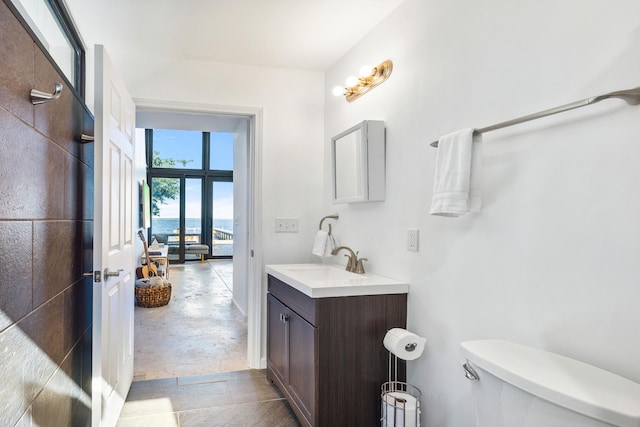 bathroom with vanity, concrete flooring, and toilet