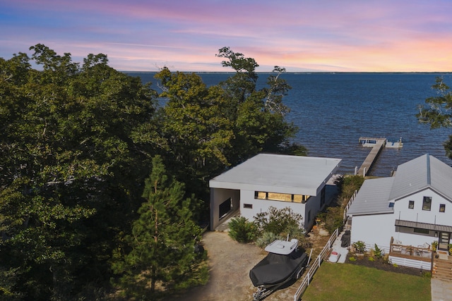 aerial view at dusk featuring a water view