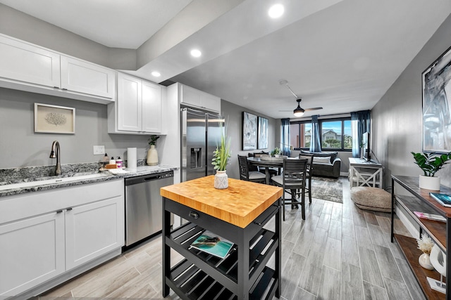 kitchen featuring ceiling fan, sink, white cabinets, and appliances with stainless steel finishes