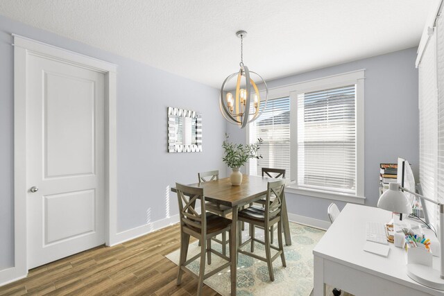 dining area featuring a chandelier, a textured ceiling, and dark hardwood / wood-style flooring