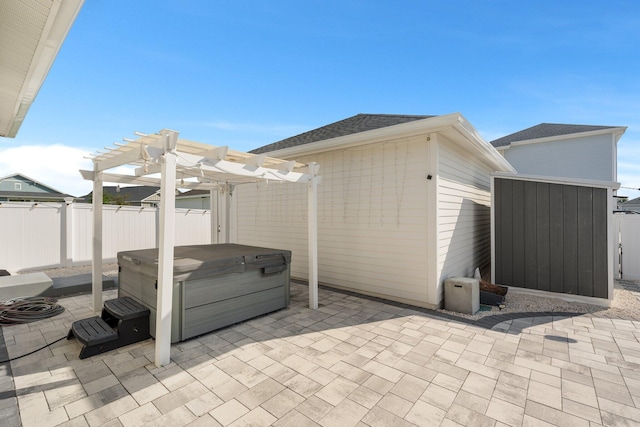 view of patio with a hot tub and a pergola