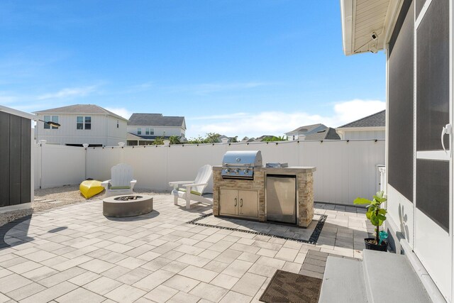 view of patio / terrace with area for grilling, an outdoor fire pit, and an outdoor kitchen