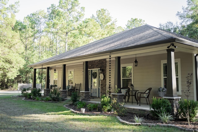 rear view of house with a porch and a yard