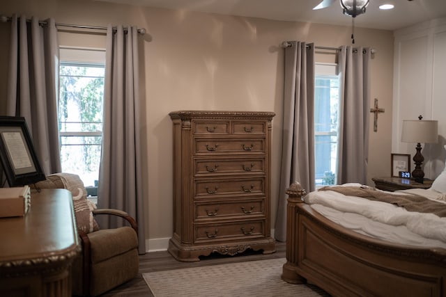 bedroom featuring multiple windows, dark hardwood / wood-style floors, and ceiling fan