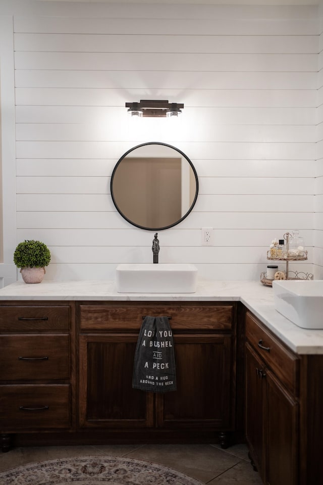 bathroom featuring vanity, tile patterned flooring, and wood walls