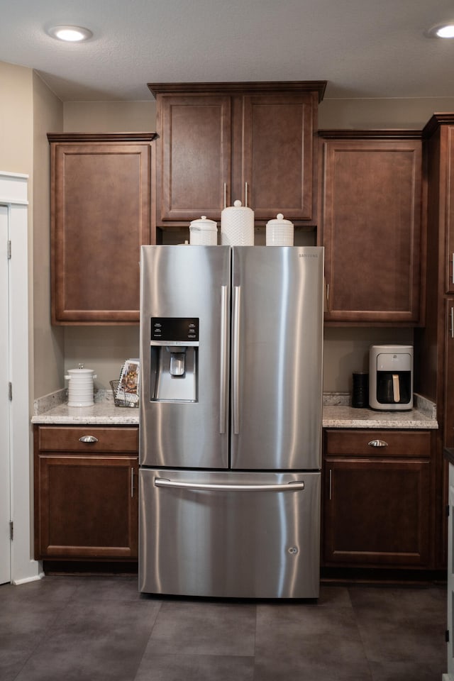 kitchen with stainless steel fridge with ice dispenser and dark brown cabinets