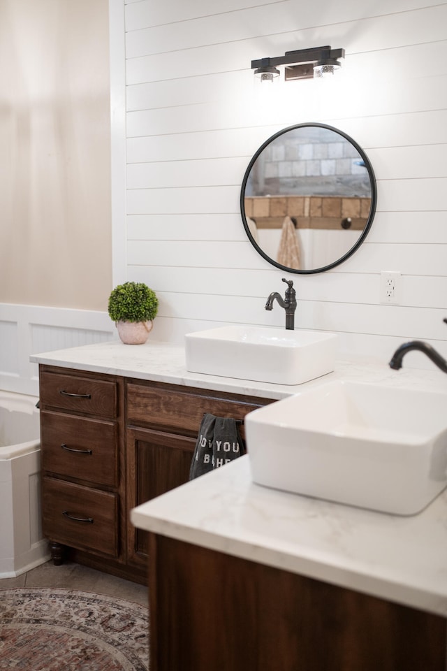 bathroom with vanity and wood walls