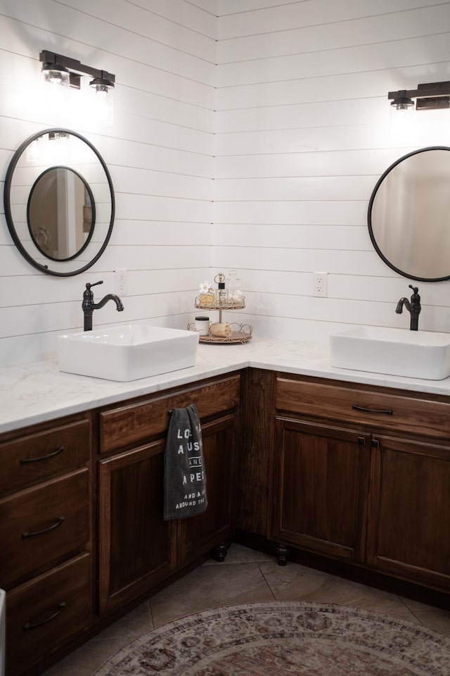 bathroom with vanity, wooden walls, and tile patterned flooring