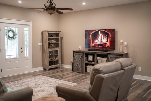 living room featuring dark wood-type flooring and ceiling fan