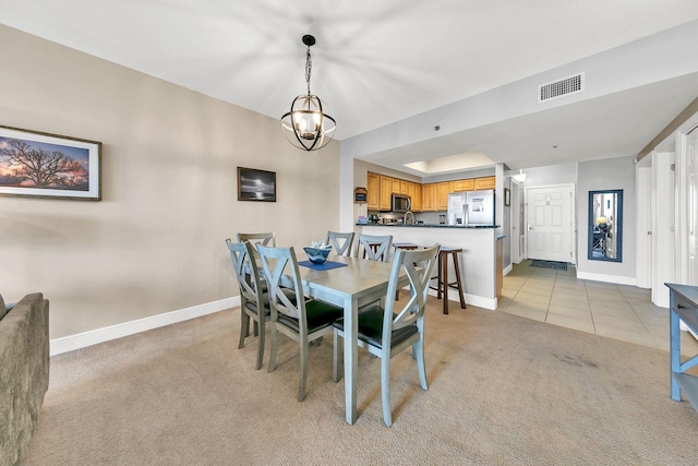 dining space featuring light colored carpet and a notable chandelier