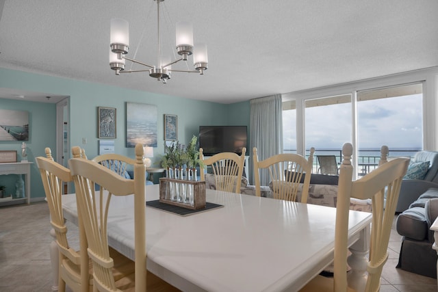 dining room with a notable chandelier, light tile patterned floors, and a textured ceiling