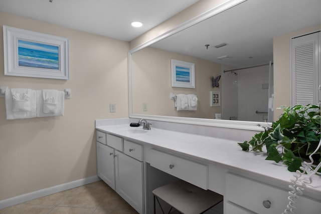 bathroom featuring vanity, a tile shower, and tile patterned floors