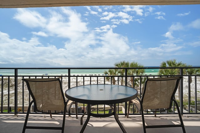 balcony featuring a view of the beach and a water view