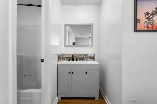 bathroom with wood finished floors, a textured ceiling, a shower, and vanity
