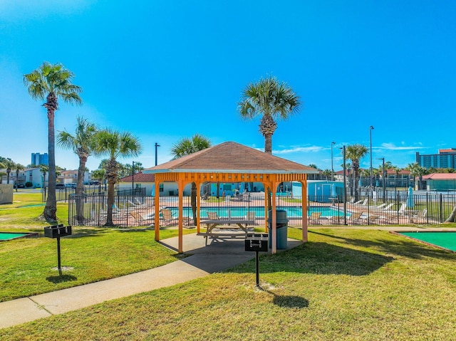 view of community with a lawn, a gazebo, a swimming pool, and fence
