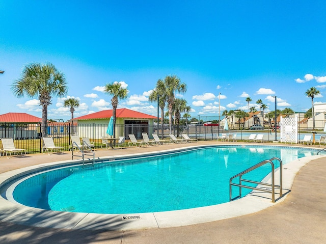 pool with a patio area and fence