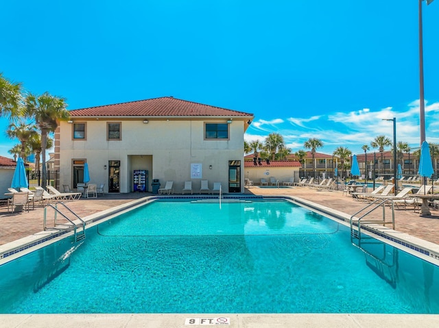 pool with a patio and fence