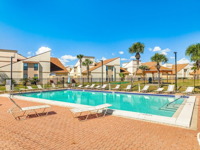 pool featuring a patio, fence, and a residential view