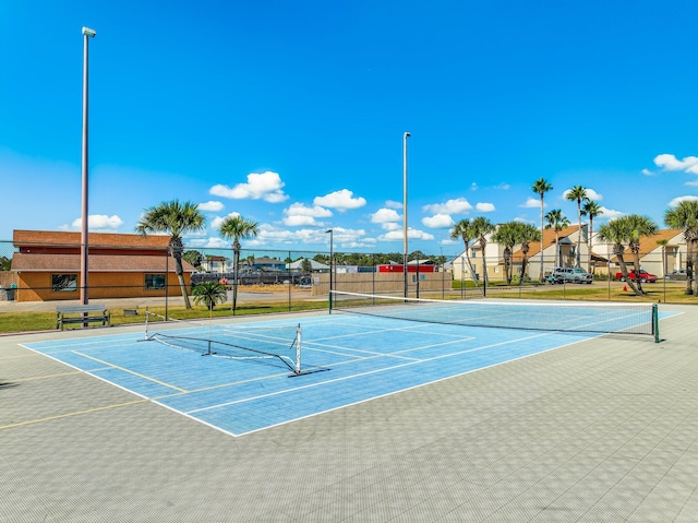 view of tennis court with fence and community basketball court