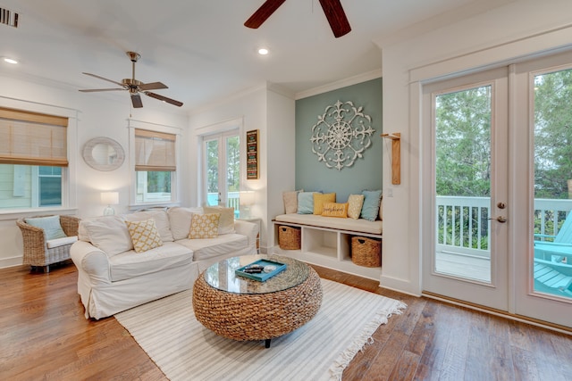 living room featuring ceiling fan, hardwood / wood-style flooring, and crown molding