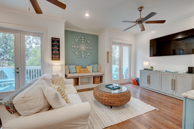 living room featuring crown molding, ceiling fan, french doors, and light hardwood / wood-style flooring