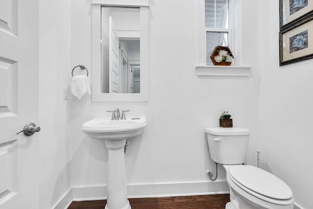 bathroom with hardwood / wood-style flooring and toilet