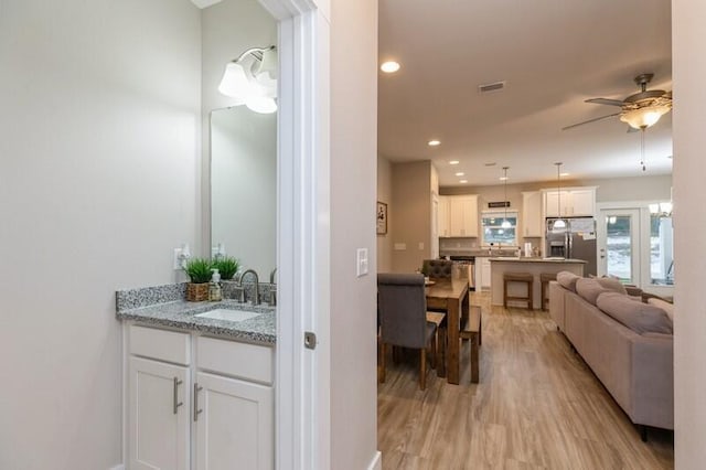 interior space with sink, hardwood / wood-style flooring, and ceiling fan