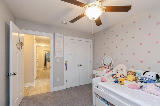 bedroom with a closet, ceiling fan, and light carpet