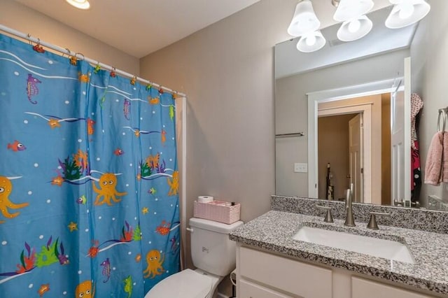 bathroom with vanity, curtained shower, and toilet