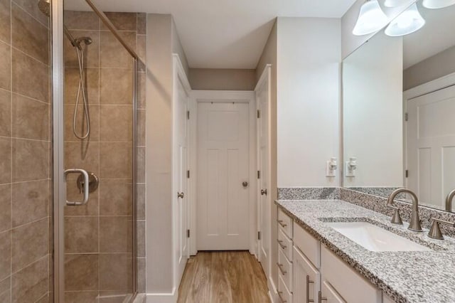 bathroom featuring vanity, hardwood / wood-style flooring, and walk in shower