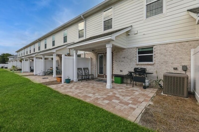 back of property with a yard, a patio area, and central AC unit