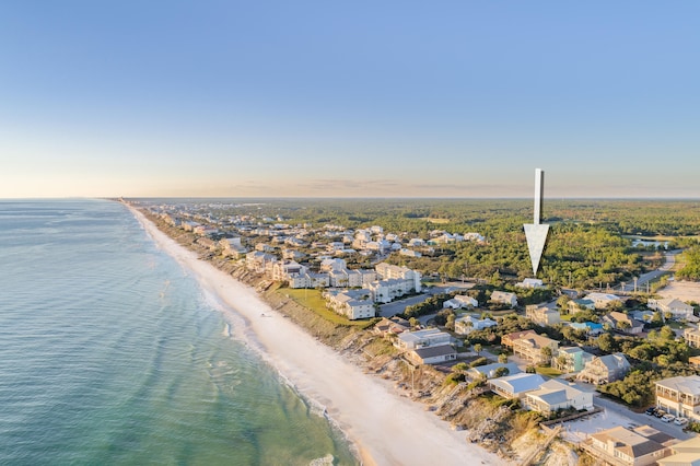 aerial view at dusk with a water view and a view of the beach