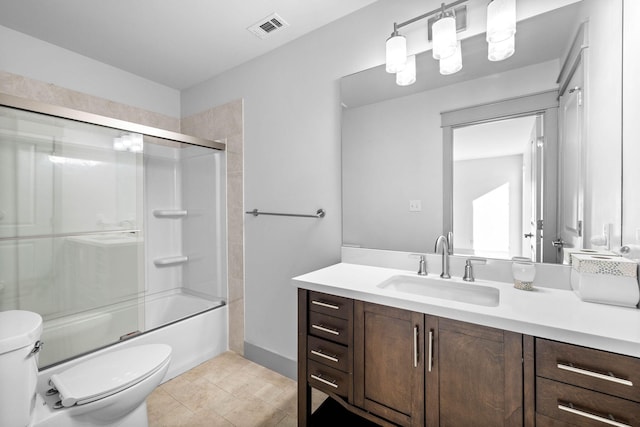 full bathroom featuring vanity, bath / shower combo with glass door, and toilet