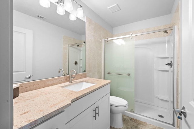 bathroom featuring vanity, toilet, and walk in shower