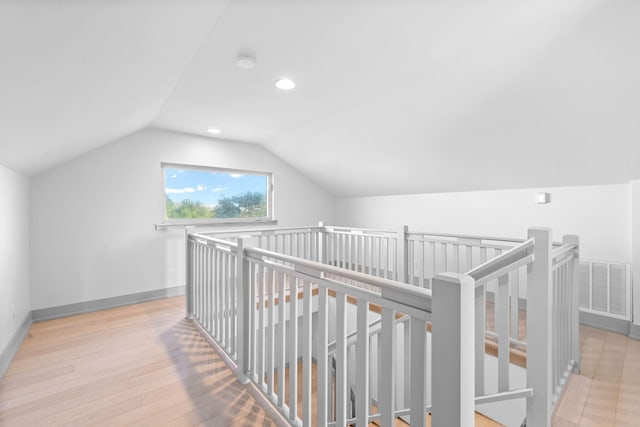 hall featuring light wood-type flooring and vaulted ceiling