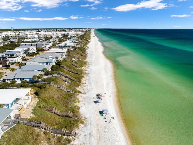 birds eye view of property with a water view and a beach view