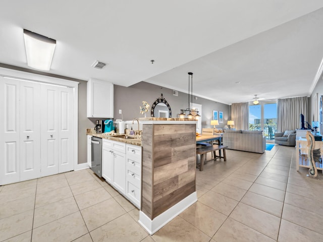 kitchen featuring dishwasher, sink, light tile patterned floors, white cabinetry, and light stone counters