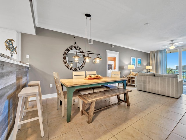 tiled dining room featuring ceiling fan and crown molding