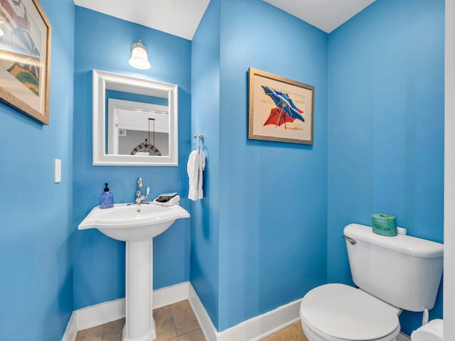 bathroom with toilet and tile patterned flooring