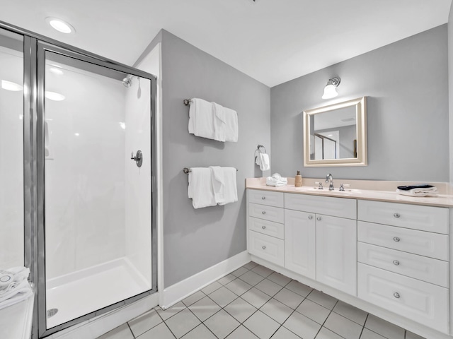 bathroom featuring a shower with door, vanity, and tile patterned flooring