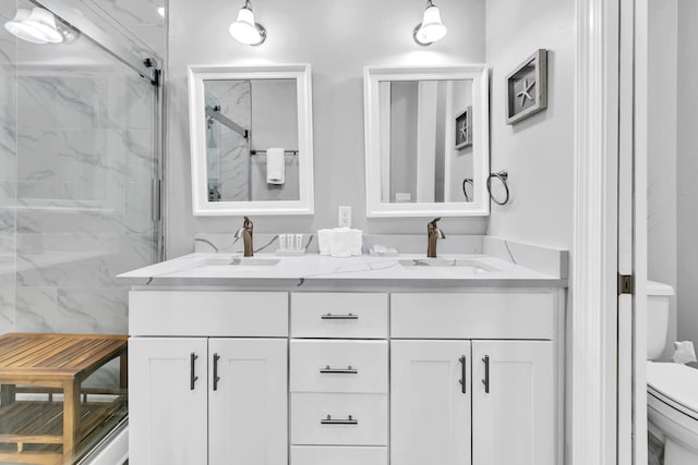 bathroom featuring a shower with door, vanity, and toilet