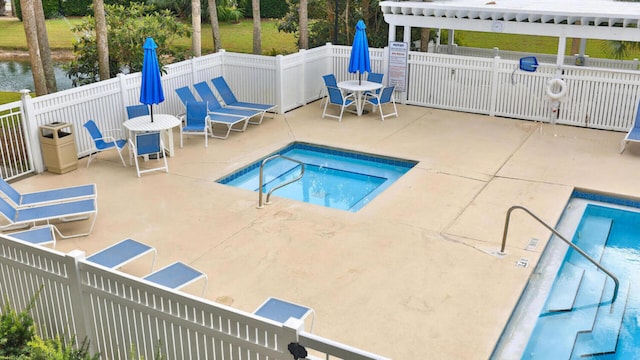 view of pool with a hot tub and a patio area